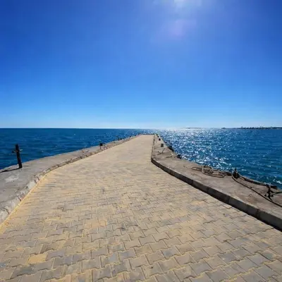 a pathway leading to the ocean on a clear day at البرنسيسة in Hurghada