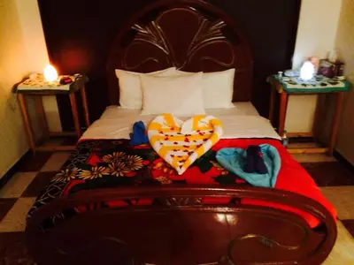 a bedroom with a bed with two candles on two tables at Sphinx in Al Karnak