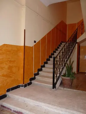 a staircase in a house with a wooden stair case at Sphinx in Al Karnak