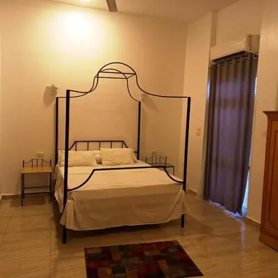 a bedroom with a bed with a metal frame at Entire Oasis Villa - Heart of Ancient Luxor in Luxor