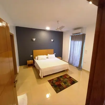 a bedroom with a bed and a blue wall at Entire Oasis Villa - Heart of Ancient Luxor in Luxor