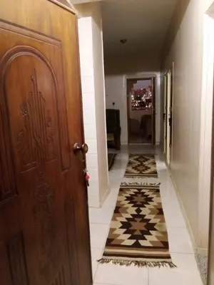 a hallway with a wooden door and a tile floor at D Guest house in Nag` el-Ramla
