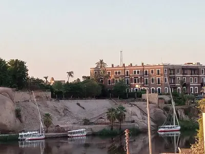 a building and boats in the water in front of a building at D Guest house in Nag` el-Ramla