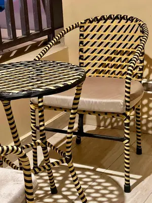 a wicker chair sitting next to a table at ALDAU village mall in Hurghada