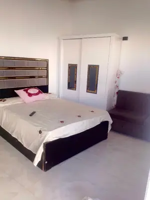 a bedroom with a large bed and a couch at بيت علي النيل مباشره في الاقصر in Jazīrat al ‘Awwāmīyah