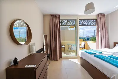 a bedroom with a bed and a desk with a mirror at Serenity Pool View Holiday Home in Hurghada
