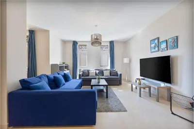 a living room with a blue couch and a tv at Serenity Pool View Holiday Home in Hurghada