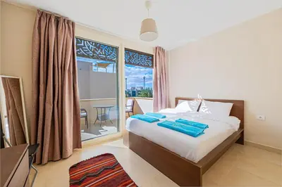 a bedroom with a bed and a large window at Serenity Pool View Holiday Home in Hurghada