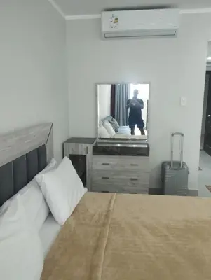 a bedroom with a bed and a dresser with a mirror at scandic Beach Hurghada in Hurghada