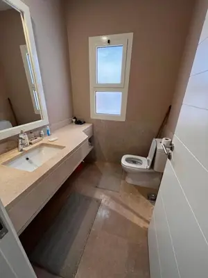 a bathroom with a sink and a toilet and a window at Cozy 1-bedroom Joubal lagoon apartment in Hurghada