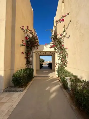 an archway with flowers on the side of a building at Cozy 1-bedroom Joubal lagoon apartment in Hurghada