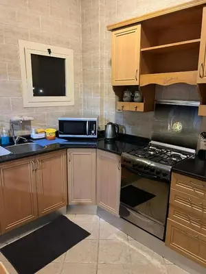 a kitchen with wooden cabinets and a stove top oven at green garden resort in Hurghada