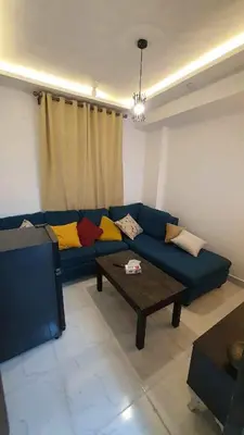 a living room with a blue couch and a coffee table at La Luna Garden Magawish in Hurghada