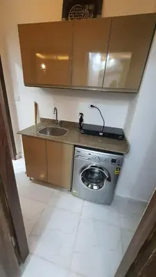 a kitchen with a sink and a washing machine at La Luna Garden Magawish in Hurghada