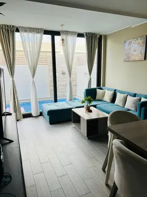 a living room with a blue couch and large windows at Bali chalet with private heated pool in Hurghada