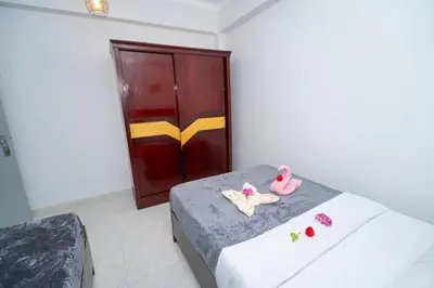 a bedroom with a bed with pink shoes on it at Queen of Merit in Luxor