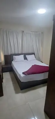 a bedroom with a large bed with white sheets at Hurghada Tiba Golden Beach Resort Down Town in Hurghada