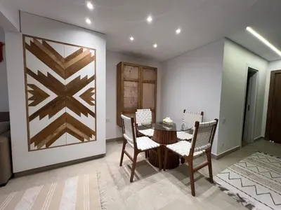 a dining room with a table and chairs and a wall at Maraya El Gouna in Hurghada