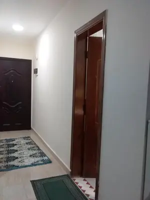 a bathroom with a wooden door and a rug at Rich Home Hurghada in Hurghada