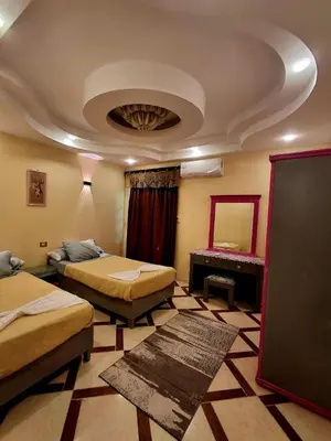 a hotel room with two beds and a mirror at El Agamy Hotel Apartment in Luxor