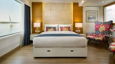 a bedroom with a large bed and a large window at سحس جروب in Luxor
