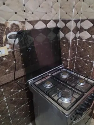 a stove in a kitchen with a tiled wall at شقة صغيرة قريبة من شاطئ البحر في سفاجا in Safaga