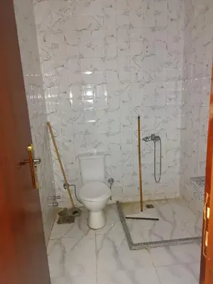 a bathroom with a toilet in a white tiled wall at ميراج باى in Hurghada
