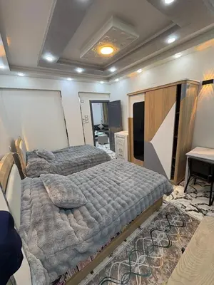 a bedroom with two beds and a television in it at fayrouz in Al Aqālitah