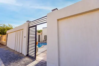 a white wall with a door leading to a swimming pool at Private Villa AL Mamsha Private Pool in Hurghada