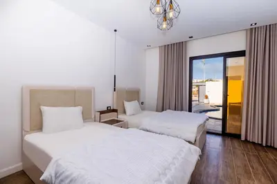 a hotel room with two beds and a window at Private Villa AL Mamsha Private Pool in Hurghada