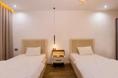 two beds in a room with a desk and a room at Private Villa AL Mamsha Private Pool in Hurghada