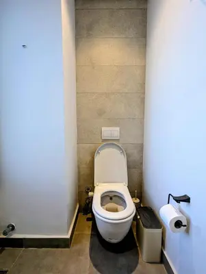 a small bathroom with a toilet in a stall at New Modern Boutique 2BR - Sunset & Sea views in Hurghada