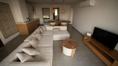 a living room with a couch and a flat screen tv at New Modern Boutique 2BR - Sunset & Sea views in Hurghada