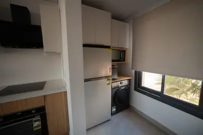 a small kitchen with a refrigerator and a window at New Modern Boutique 2BR - Sunset & Sea views in Hurghada