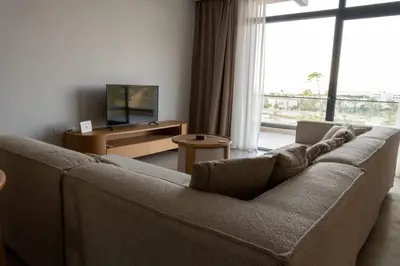 a living room with a couch and a large window at New Modern Boutique 2BR - Sunset & Sea views in Hurghada