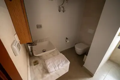 a small bathroom with a toilet and a sink at New Modern Boutique 2BR - Sunset & Sea views in Hurghada