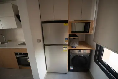 a small kitchen with a refrigerator and a microwave at New Modern Boutique 2BR - Sunset & Sea views in Hurghada
