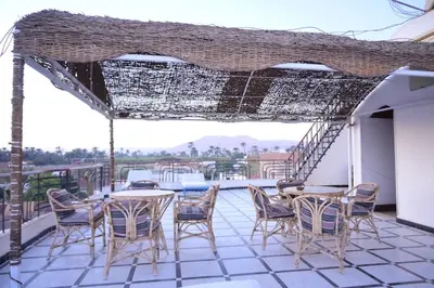 a patio with tables and chairs on a balcony at Qasr El Nil in Luxor