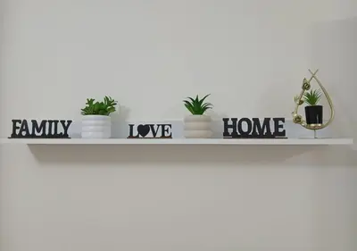 a shelf with plants in pots on a white wall at Modern Apartment in the Britsh Resort in Hurghada