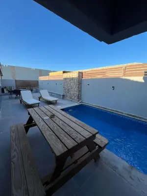 a wooden picnic table next to a swimming pool at Bali elgouna private heated pool in Hurghada