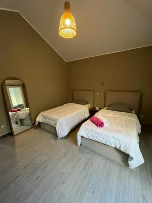 a bedroom with two beds and a mirror and a lamp at Bali elgouna private heated pool in Hurghada