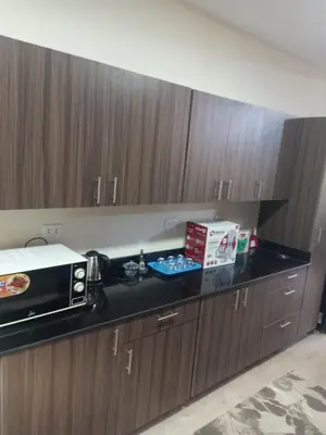 a kitchen with wooden cabinets and a black counter top at Sky Star Villa 97 in Hurghada
