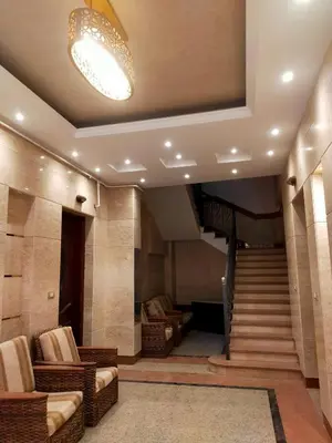 a lobby with a staircase and chairs and a light at happy apartment in Luxor