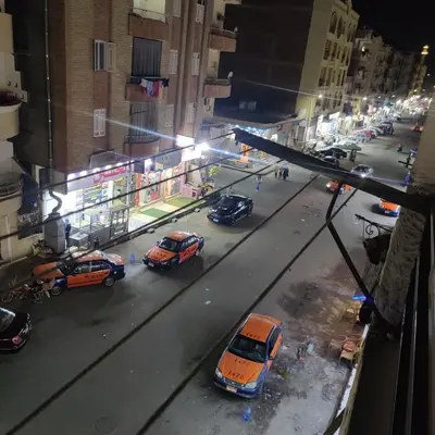 a group of taxis parked on a city street at night at Appartement 2 slaapkamers in Hurghada