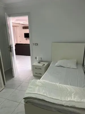a white bedroom with a bed and a mirror at Hobby live in Hurghada in Hurghada