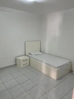a white bedroom with a bed and a nightstand at Hobby live in Hurghada in Hurghada
