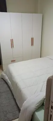 a bedroom with a white bed with white cabinets at Cozy flat in Makadi Heights in Hurghada