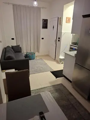 a living room with a couch and a kitchen at Cozy flat in Makadi Heights in Hurghada