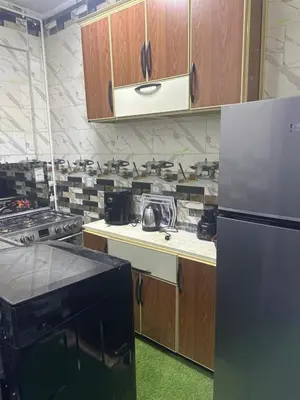 a kitchen with wooden cabinets and a refrigerator at أسوان in Aswan