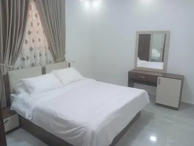 a bedroom with a white bed and a mirror at Luxor Hostel Place in Al Baghdādī